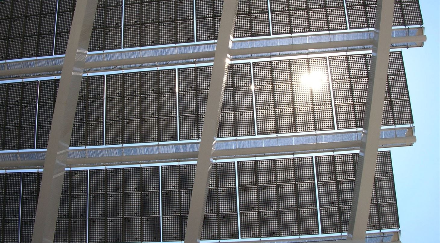 Billedet viser et solcellepanel, hvor solen giver genskin i panelerne